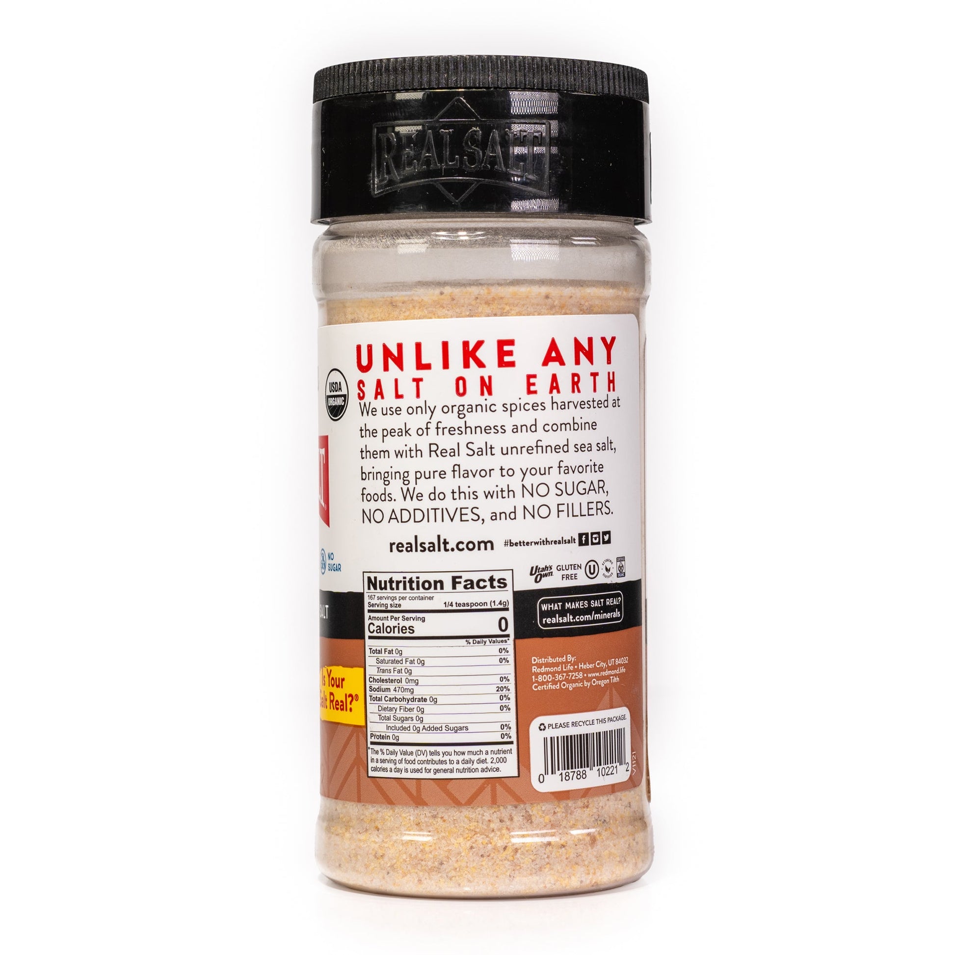 Clear shaker of Real Salt brand organic seasoned salt on a white background, showcasing the nutritional information and company branding.